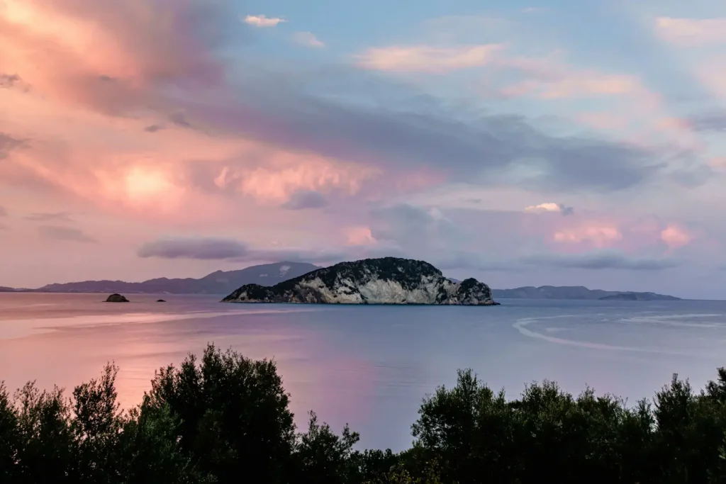 body of water near mountain during sunset